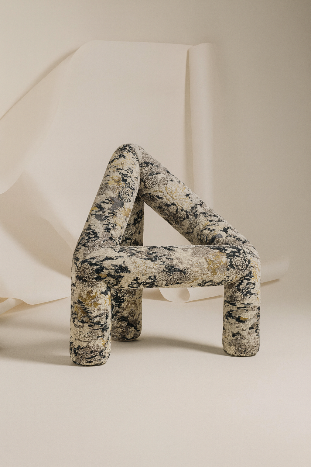 Decorative object shaped like the number '4' with a floral pattern on a neutral background