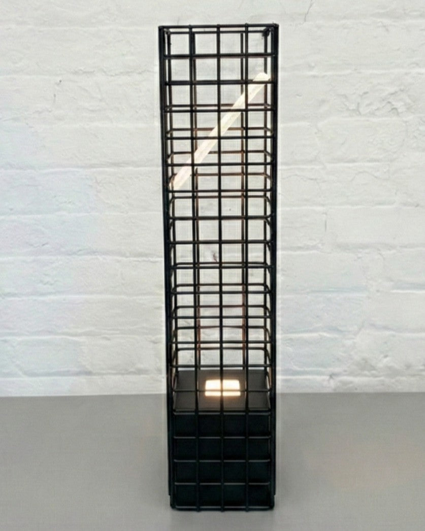 Black metal grid lamp on a white textured wall background