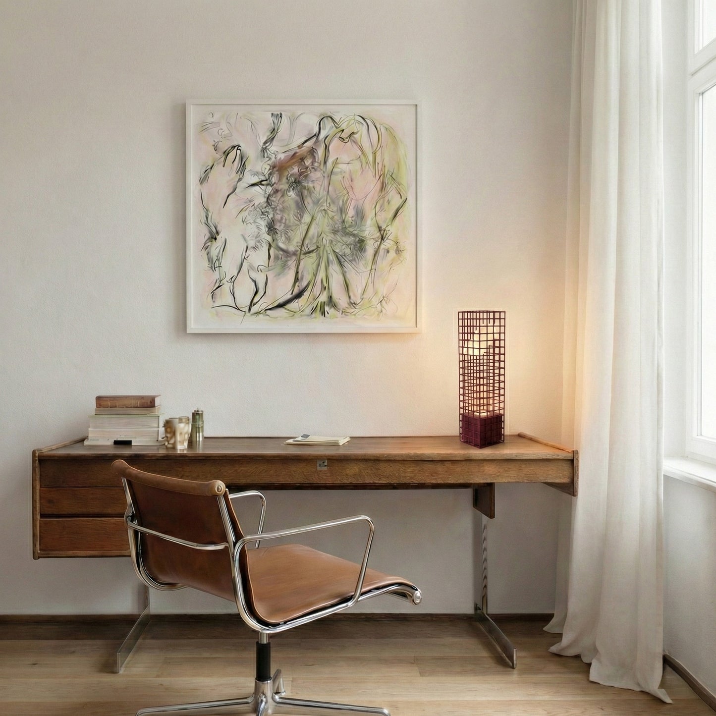 Modern home office with wooden desk, leather chair, and abstract art on the wall. A maroon mesh lamp is lighted up on the desk.